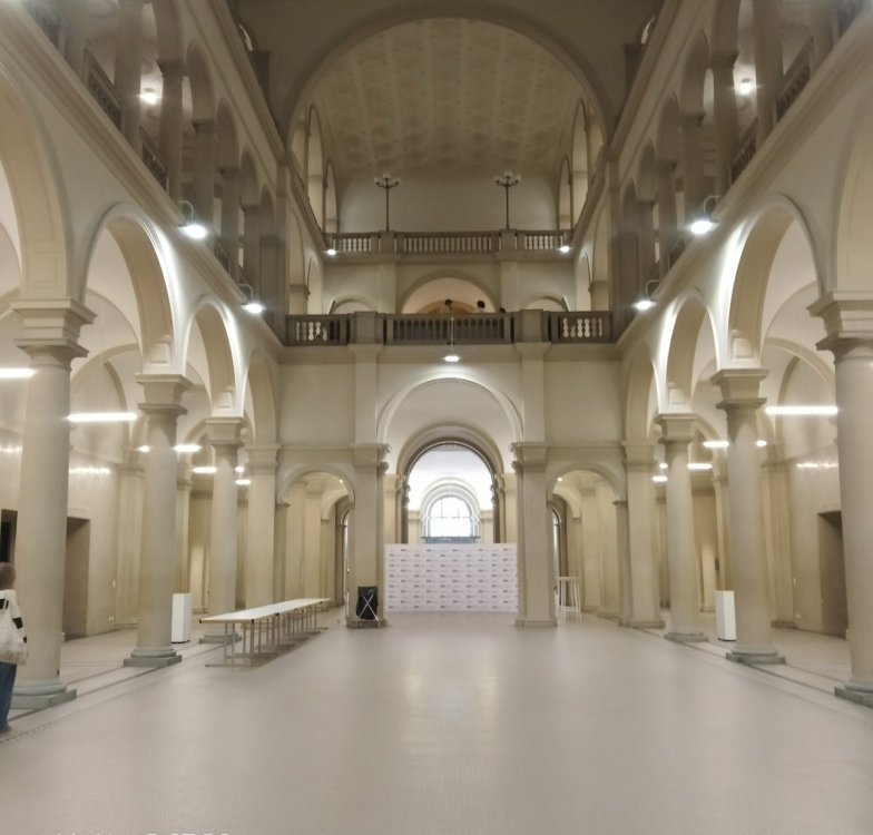„Monumentalny hol głównego gmachu ETH Zürich z wysokimi arkadami, kamiennymi kolumnami i reprezentacyjnymi schodami Politechniki Federalnej w Zurychu.”