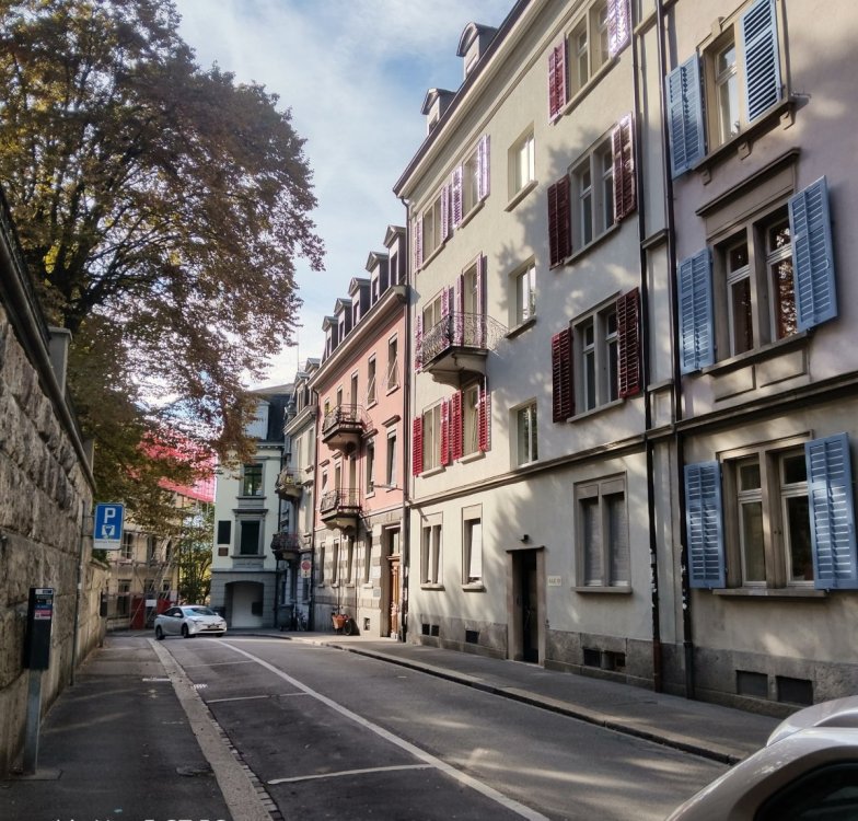 Historyczna uliczka Auf der Mauer w Zurychu z zabytkowymi kamienicami, kolorowymi okiennicami i ozdobnymi fasadami budynków.